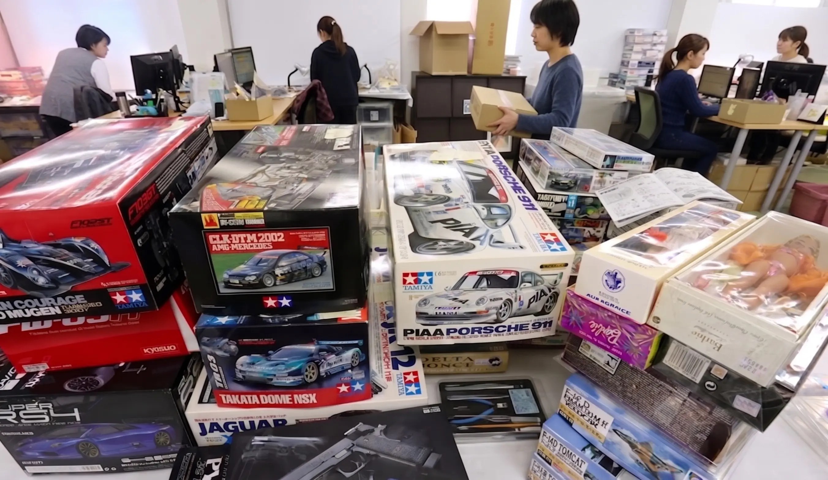 ホビー用品を確認する査定スタッフと社内の様子